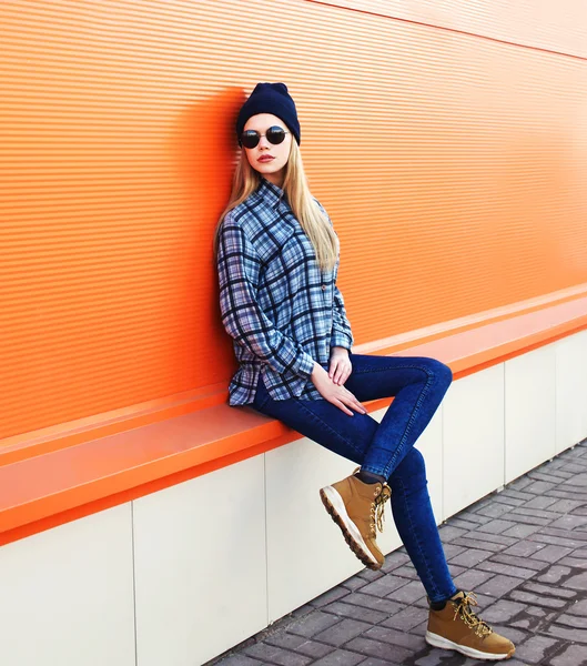 Fashion model woman in city over orange background