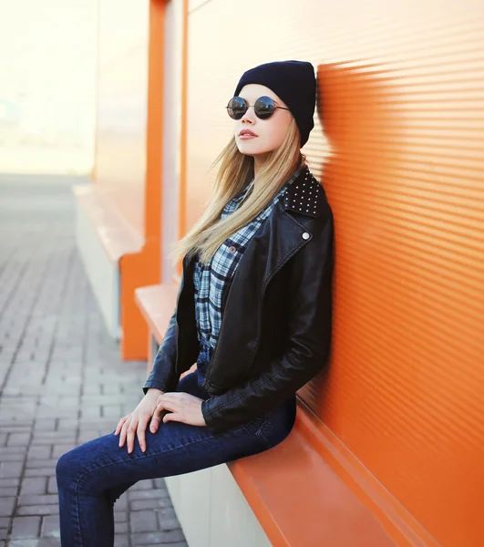 Fashion pretty blonde woman wearing a black rock style in city