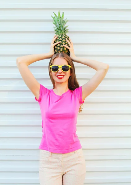 Fashion pretty woman in sunglasses with pineapple over white bac