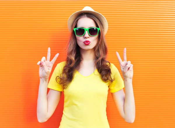 Fashion pretty woman in sunglasses over colorful orange backgrou