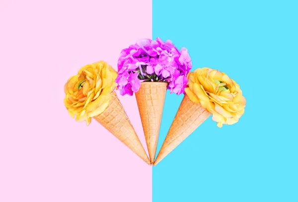 Three ice cream cone with colorful flowers over pink blue backgr
