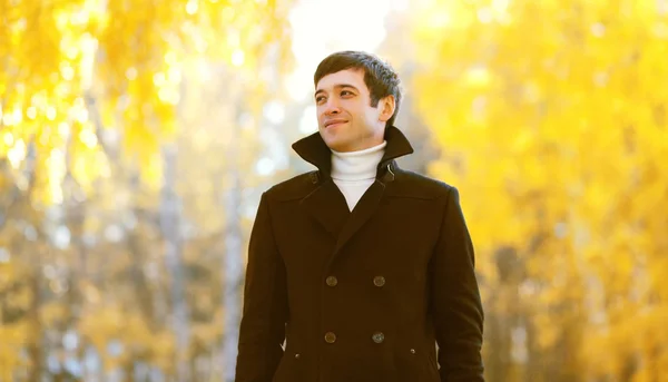 Portrait of handsome smiling man wearing a black coat jacket in