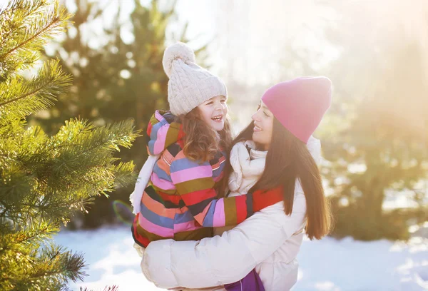 Winter and people concept - mother and child having fun playing