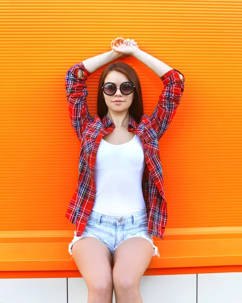 Fashion pretty woman in the sunglasses and checkered shirt posin