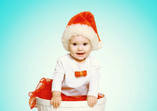 Christmas and people concept - happy smiling baby in santa red h