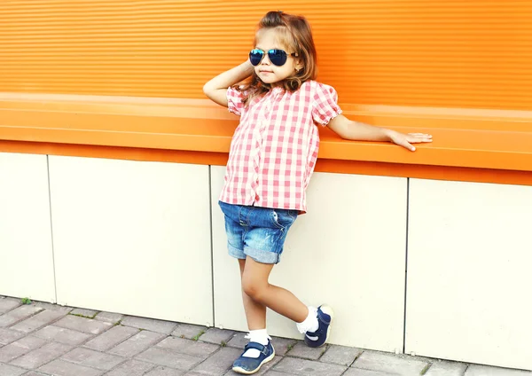 Fashion little girl child wearing a sunglasses and checkered shi