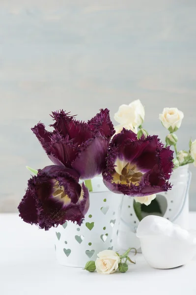 Vintage still life. White rose, purple tulips