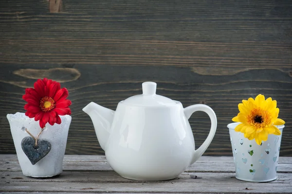 White teapot and yellow red flower