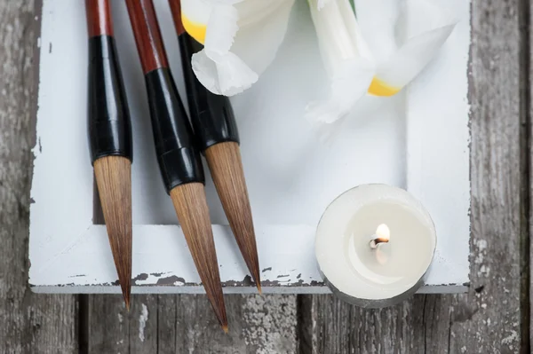 Candle, irisis and Chinese writing brush pens
