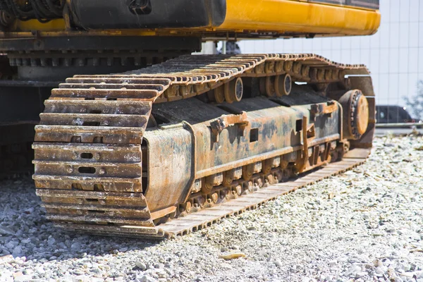 Detail of the track of a digging machine and moving earth at construction site