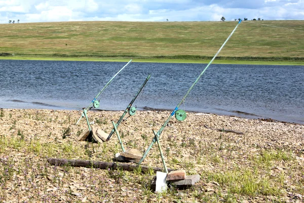 Fishing-rods with stone supports on a beach on the Yenisei river in Russia