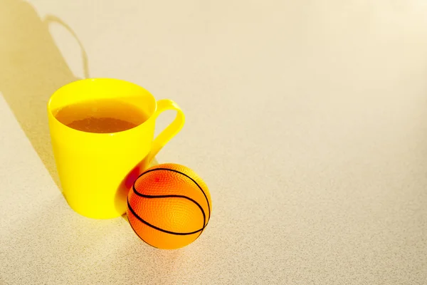 Basketball with yellow cup juice in the morning