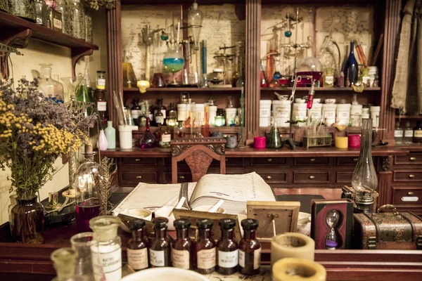 Various flasks, jars and herbs on the shelves  in old pharmacy