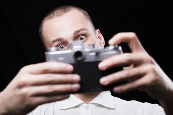 Happy young man photographing himself on a retro camera