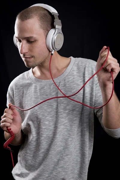 Young man listening to music on headphones and dancing