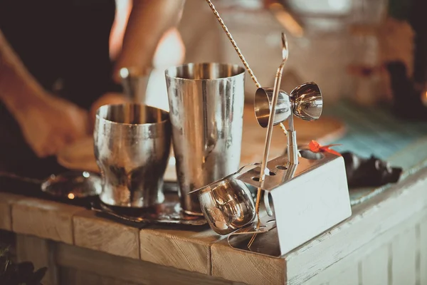 Cocktail shaker with measuring cup and citruses.