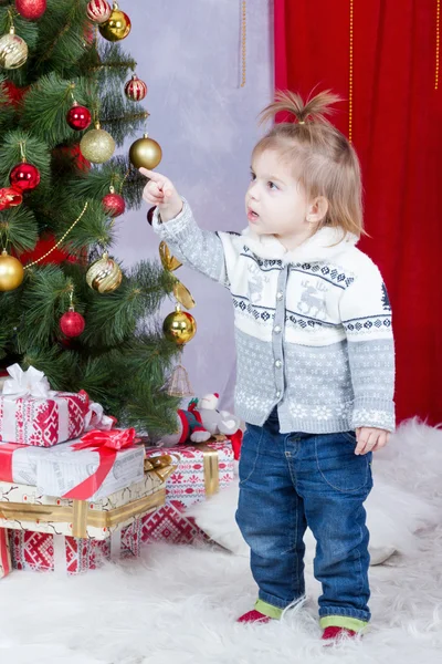 Child points his finger on a Christmas tree