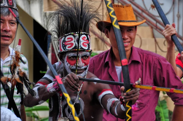 JAKARTA, INDONESIA- AUGUST 7, 2015 : native of Irian Jaya showing tourists how to use traditional bow with arrow for hunting in Beautiful Indonesia Miniature Park, Jakarta.