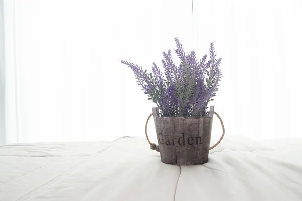 The bed with purple lavender flower and sunlight from glass of windows in bedroom.