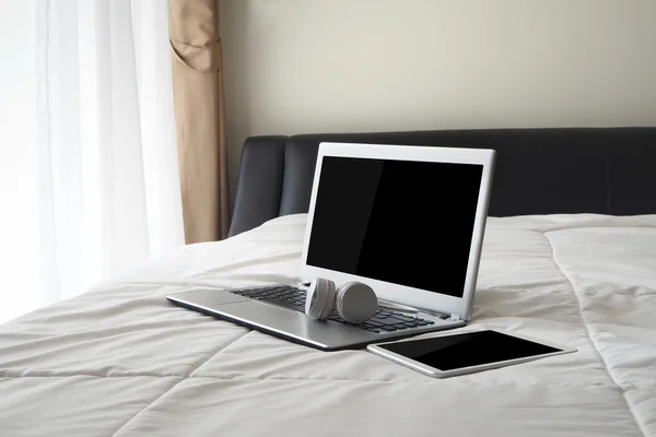 The bed with blank screen notebook and blank screen  tablet.