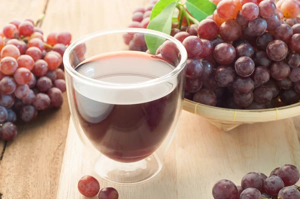 Grape juice and group of Grapes on bamboo basket.