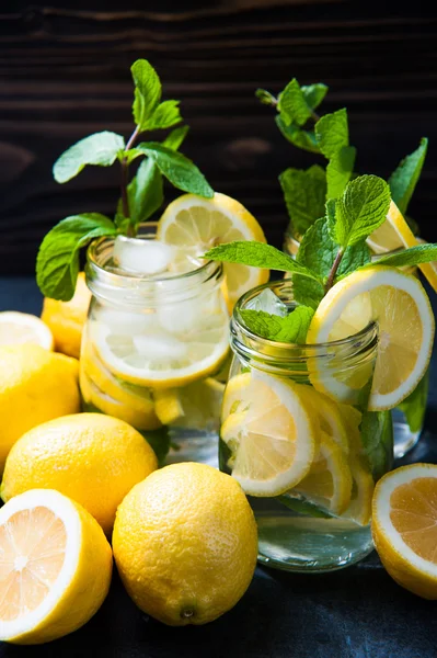 Composition of lemonades, lemons and mint on stone table background