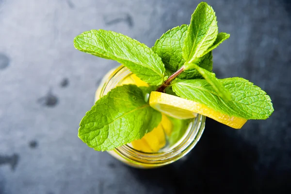 Glass of lemonade with lemons and fresh mint, top view