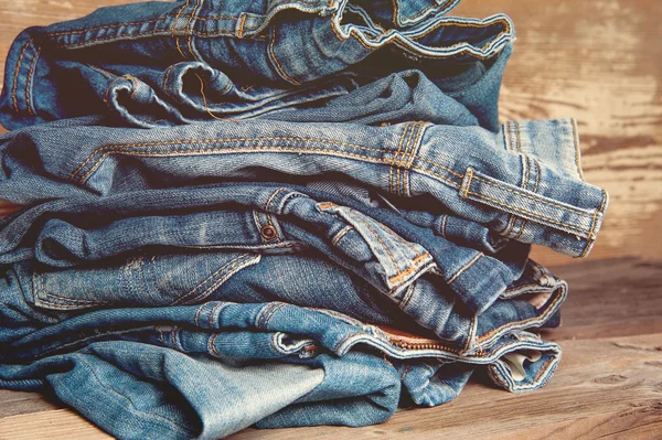 Pile of Old Indigo Jeans Denim on Wooden Table