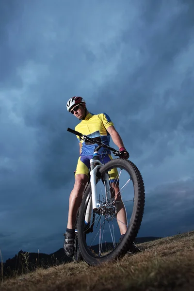 Mountain Bike cyclist posing on background outdoor hill