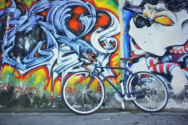 Bicycle near wall with graffiti