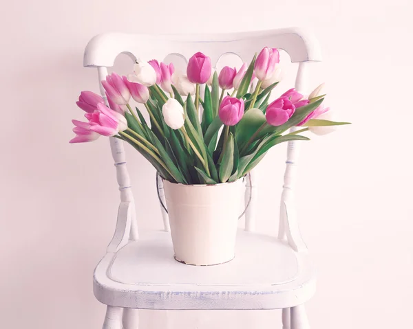 Bright tulips on chair