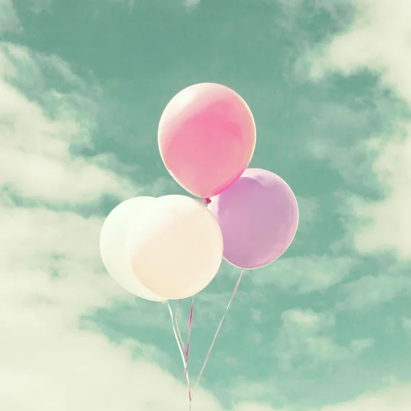 Colorful balloons over vintage sky