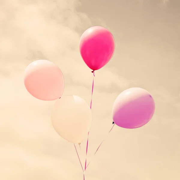 Colorful balloons over vintage sky