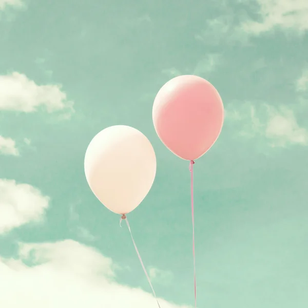 Colorful balloons over vintage sky