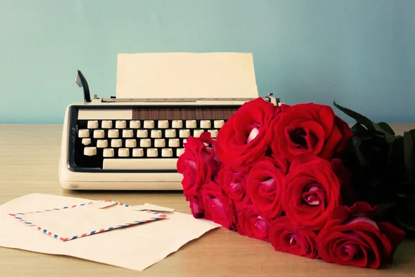 Vintage typewriter and bouquet of roses