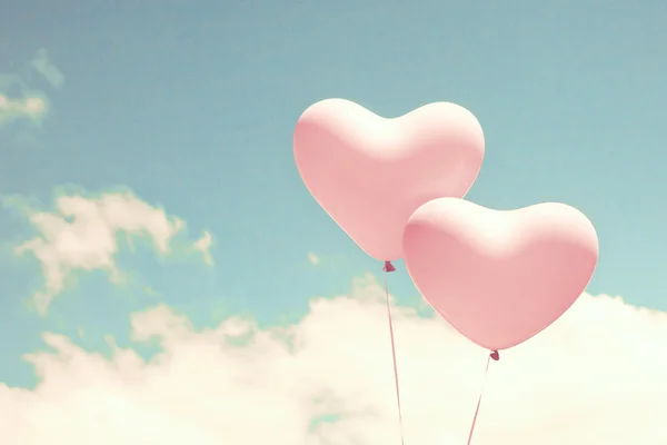 Retro pink heart shaped balloons in flight