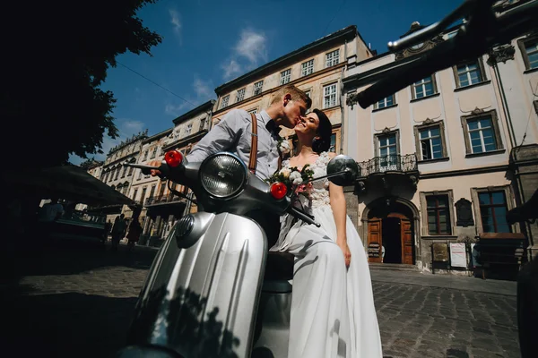 Bride and groom on vintage motor scooter