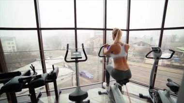 女孩骑着自行车在健身房 - 图库视频影像 simb