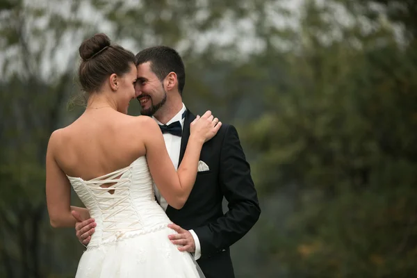 Bride and groom dance together in the woods