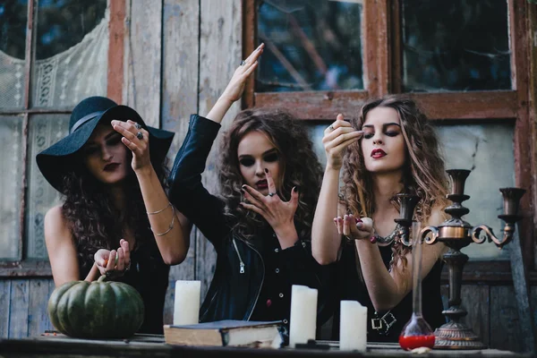 Three vintage witches perform magic ritual