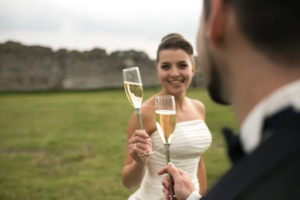 Bridal couple clink glasses of champagne