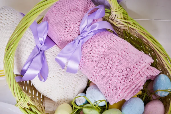 Wicker basket Easter set with colored eggs hay crocheted blankets covered with silk satin ribbon easter holy celebration, happy