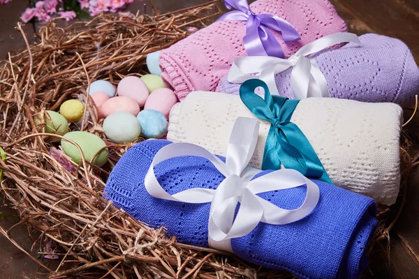 Wicker nest Easter set with colored eggs hay crocheted blankets covered with silk satin ribbon easter holy celebration, happy, present