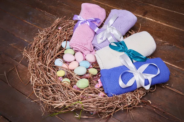 Wicker nest Easter set with colored eggs hay crocheted blankets covered with silk satin ribbon easter holy celebration, happy, present