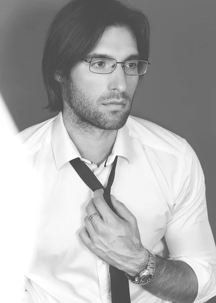 Black and white portrait of handsome smartlooking .intelligent businesslike Financier or agent or manager in eyeglasses and white shirt and tie