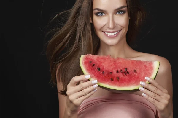 Beautiful sexy brunette woman eating watermelon on a white background, healthy food, tasty food, organic diet, smile healthy, black background passion
