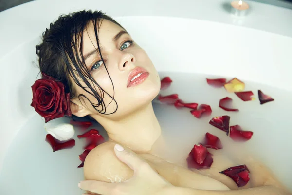 Beautiful sexy woman takes bath rose candles Valentine's day spa