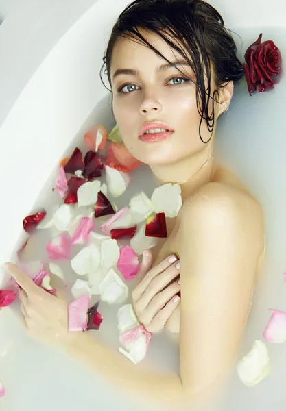 Beautiful sexy woman takes bath rose candles Valentine's day spa