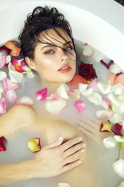 Beautiful sexy woman takes bath rose candles Valentine\'s day spa