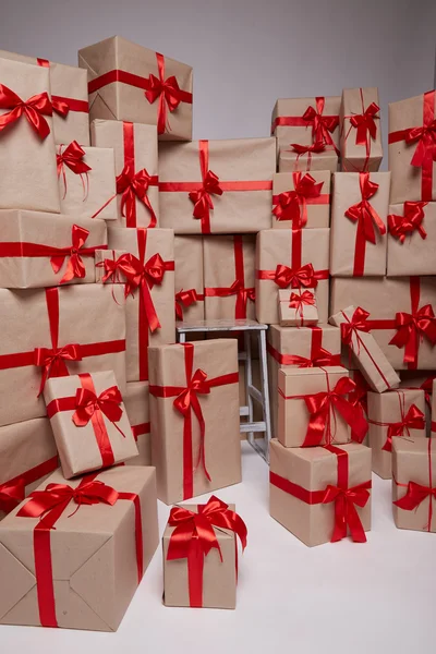 Many gifts, boxes with gifts covered with red satin and silk ribbon with big bow, merry Christmas and a happy new year, surprise, wishes, birthday or holiday